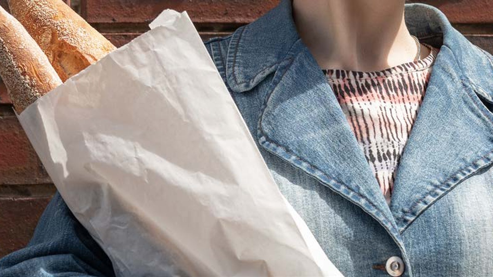 Baguettes carried in a long white breadstick bag