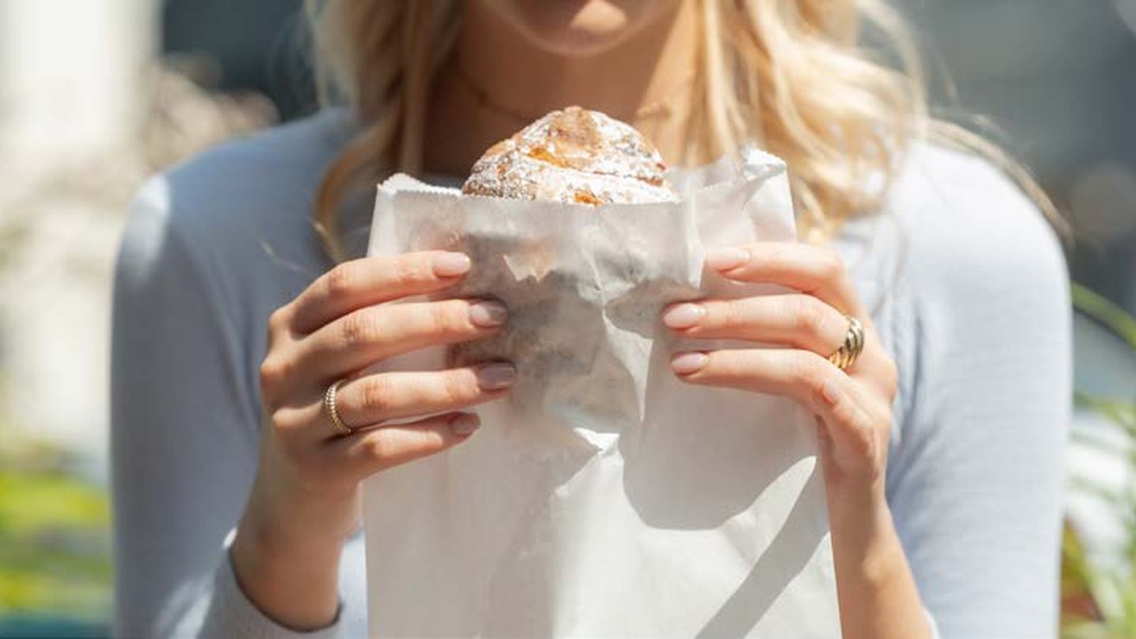 A customer carrying a filled white paper bag