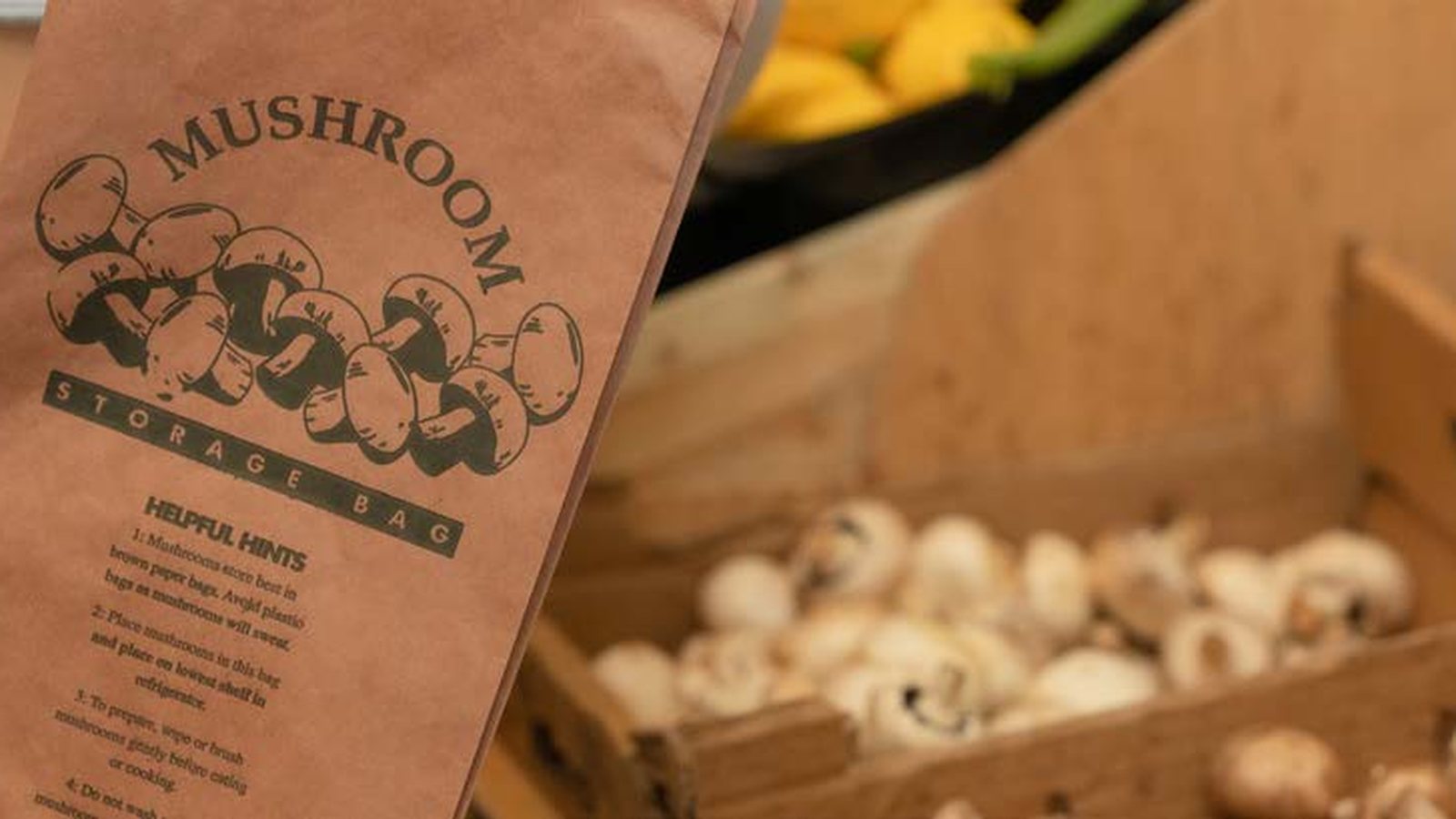A printed mushroom bag beside a crate of mushrooms