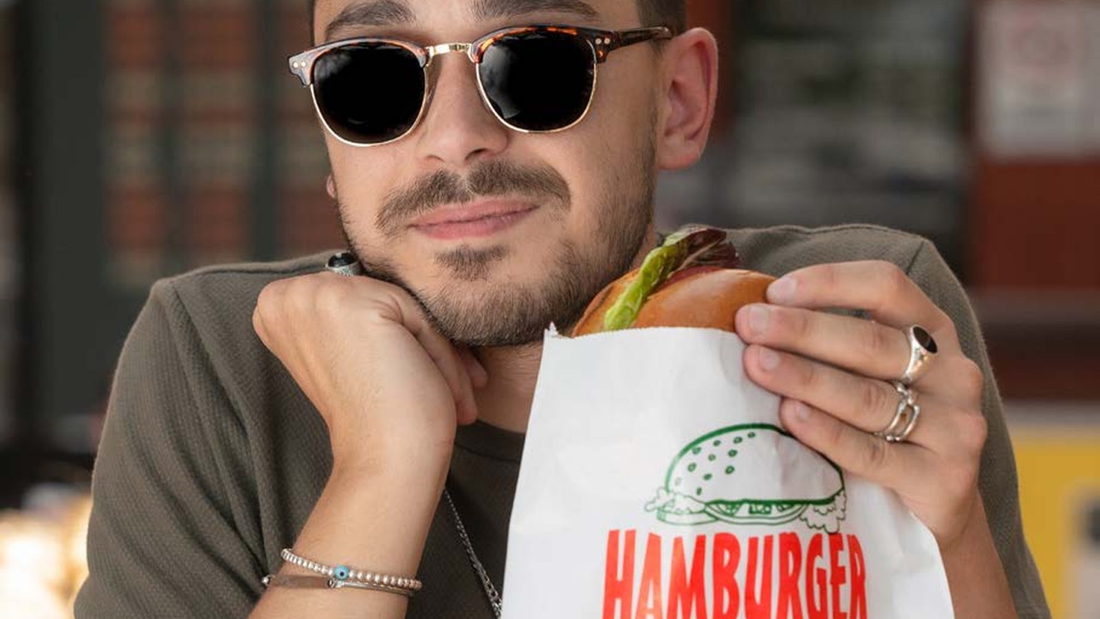 A burger held in a printed hamburger bag