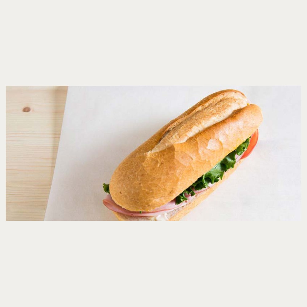 A filled baguette on a sheet of bleached wrapping paper